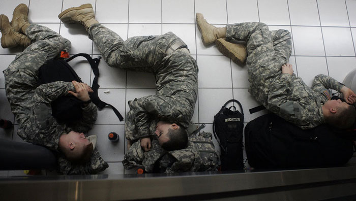Soldiers take a nap Friday morning along the side of a stairwell at Lambert International Airport. Thousands of soldiers were at Lambert for the annual exodus home for the holidays from Fort Leonard Wood.