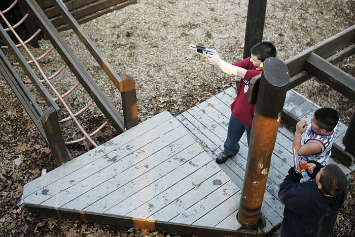 A kid takes aim and fires his airsoft pistol in the Baker Park playground. (C-T photo Max Gersh) ©2010