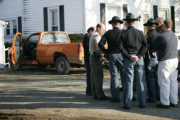 Officers from Henry and Randolph counties and state troopers stand in front of the house where two men were arrested Wednesday after a robbery. The truck in the background was allegedly the getaway vehicle. (C-T photo Max Gersh) ©2010