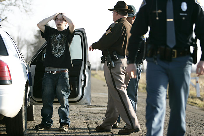 John Michael Evans places his hands on his head as Henry County Sheriff's deputies and Indiana State Troopers transfer him into the custody of the Randolph County Sheriff's Department. Evans was caught at his residence after allegedly committing armed robbery in Losantville. (C-T photo Max Gersh) ©2010