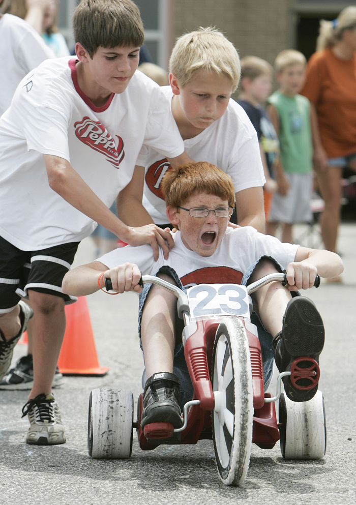 In this Wednesday May 26, 2010 photo, Jordan Rhodus lets out a  scream as teammates Grant Jessup, left, and Travis Isaacs give him a  push start out of the pit during the Titan 500 at Tri Elementary Schoo  in Straughn, Ind. Their team, No. 23 Dr. Pepper, went on to win the  race. (AP Photo/The Courier-Times, Max Gersh) ©2010