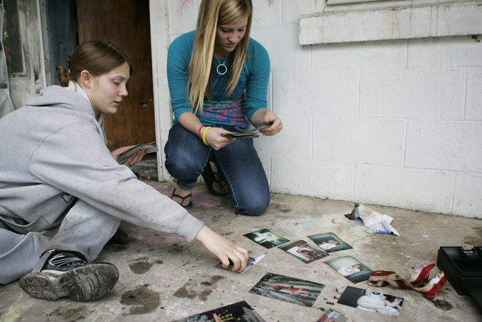 Juliana, left, and Brooke Hughes sort through salvaged photographs Wednesday afternoon. A fire broke out Wednesday morning in their shared closet while they were at school. (C-T photo Max Gersh) ©2010