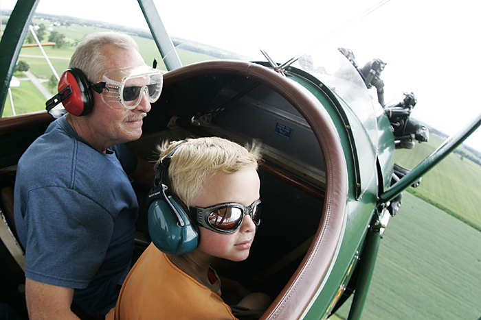 Logan Drook, 6, looks out at Henry County farm land Tuesday afternoon while taking a biplane ride with his grandpa, Roger Peckinpaugh. (C-T photo Max Gersh) ©2010