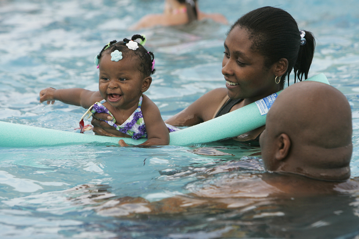 Jae Williams, six months, swims with her mother, Marquetta, and father, James Wednesday afternoon in the Aquatic Center at Baker Park. The Williams' moved to New Castle in January and this is Jae's first season in a pool. "We'll be out here every day it doesn't rain," said James Williams. (C-T photo Max Gersh) ©2010