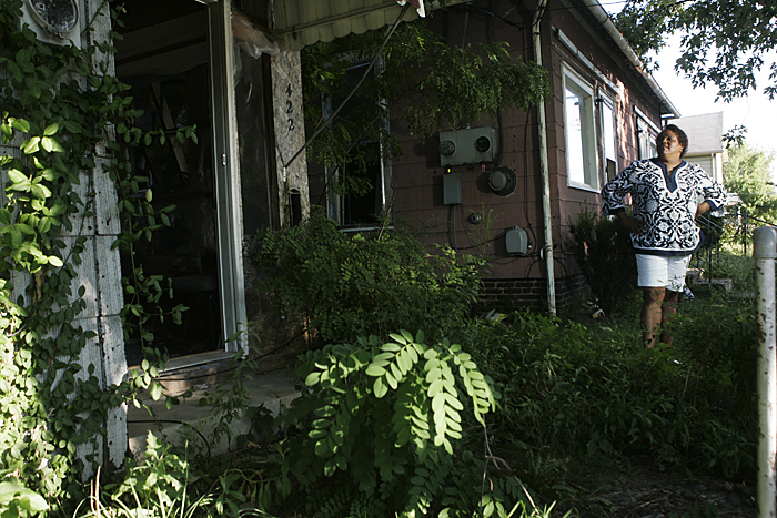 Lisa Archey stands in between two abandoned and neglected homes on August 25 along North 17th Street. Archey said that having homes like these on the block hurt the entire community. (C-T photo Max Gersh) ©2010