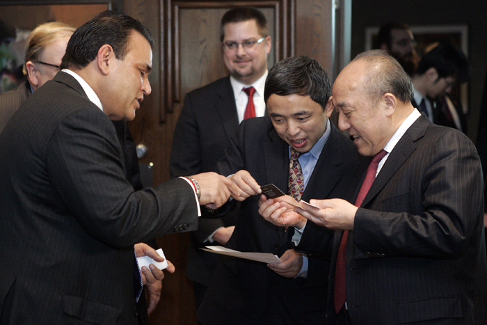 MAX GERSH | ROCKFORD REGISTER STAR Dr. Lu Guanqiu, founder and chairman of Wanxiang, (from right) and Pin Ni, president of Wanxiang America Corporation, look at Sunil Puri's business card Thursday, Jan. 20, 2011, at Giovanni's Restaurant and Convention Center in Rockford.