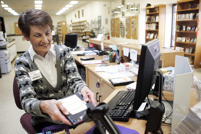 MAX GERSH | ROCKFORD REGISTER STAR Library clerk Kay Kluth scans in a DVD Tuesday, March 1, 2011, at the front counter of the Pecatonica Library. ©2011