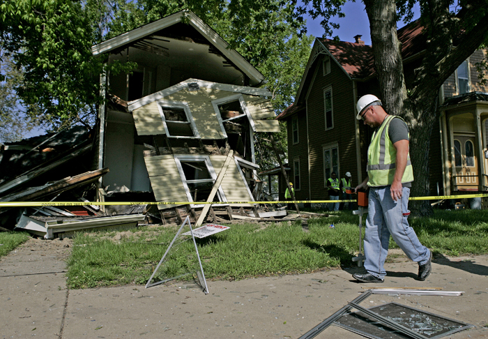 MAX GERSH | ROCKFORD REGISTER STAR A Nicor employee surveys the scene of a house explosion in the 400 block of Kishwaukee St. Friday, May 20, 2011, in Rockford. ©2011