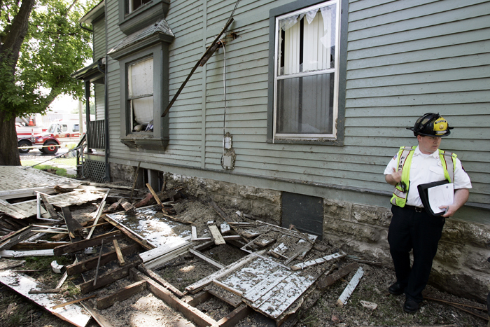 MAX GERSH | ROCKFORD REGISTER STAR Rockford Fire Investigator Tim Morris stands in between a home that exploded and the home  to its south Friday, May 20, 2011, in the 400 block of Kishwaukee Street in Rockford. The neighboring home has been condemned from extensive damage and debris caused by the explosion. ©2011