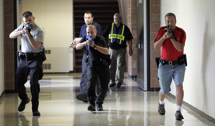 MAX GERSH | ROCKFORD REGISTER STAR Cherry Valley Police Chief Todd Houde (back right) watches as Clint Wagner (from left) of the Rockford Police Department, Jason Hergenroeder of the U.S. Marshals Service (rear center), Robert Lewis of the Roscoe Police Department and Ryan Fulton of the Cherry Valley Police Department make their way down a hall Wednesday, Aug. 10, 2011, during rapid deployment to an active shooter training at Harlem High School in Machesney Park. ©2011