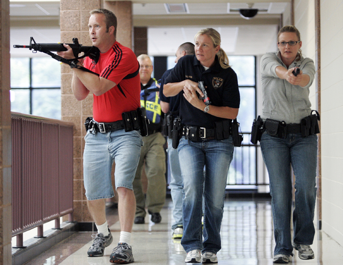 MAX GERSH | ROCKFORD REGISTER STAR Ryan Fulton (from left) of the Cherry Valley Police Department, Ashley Calhoun of the Rockford Police Department, and Adrienne Horn of the Rock Valley College Police Department clear a hallway Wednesday, Aug. 10, 2011, during rapid deployment to an active shooter training at Harlem High School in Machesney Park. ©2011