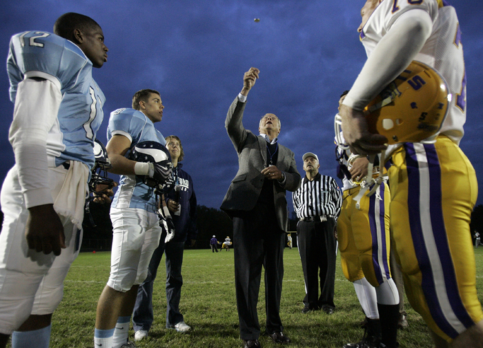 MAX GERSH | ROCKFORD REGISTER STAR Rockford School Board President Harmon Mitchell tosses a Ronald Reagan commemorative coin Friday, Sept. 23, 2011, before a game against Belvidere at Guilford High School in Rockford. © 2011