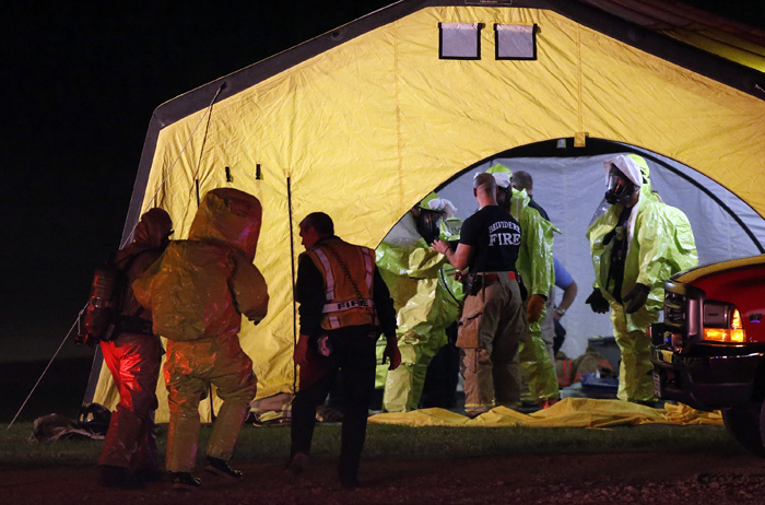 A hazardous materials team member from MABAS Division 8 is walked back to a changing tent Tuesday, June 4, 2013, at the Winnebago County Farm Bureau in Rockford. MAX GERSH/ROCKFORD REGISTER STAR ©2013