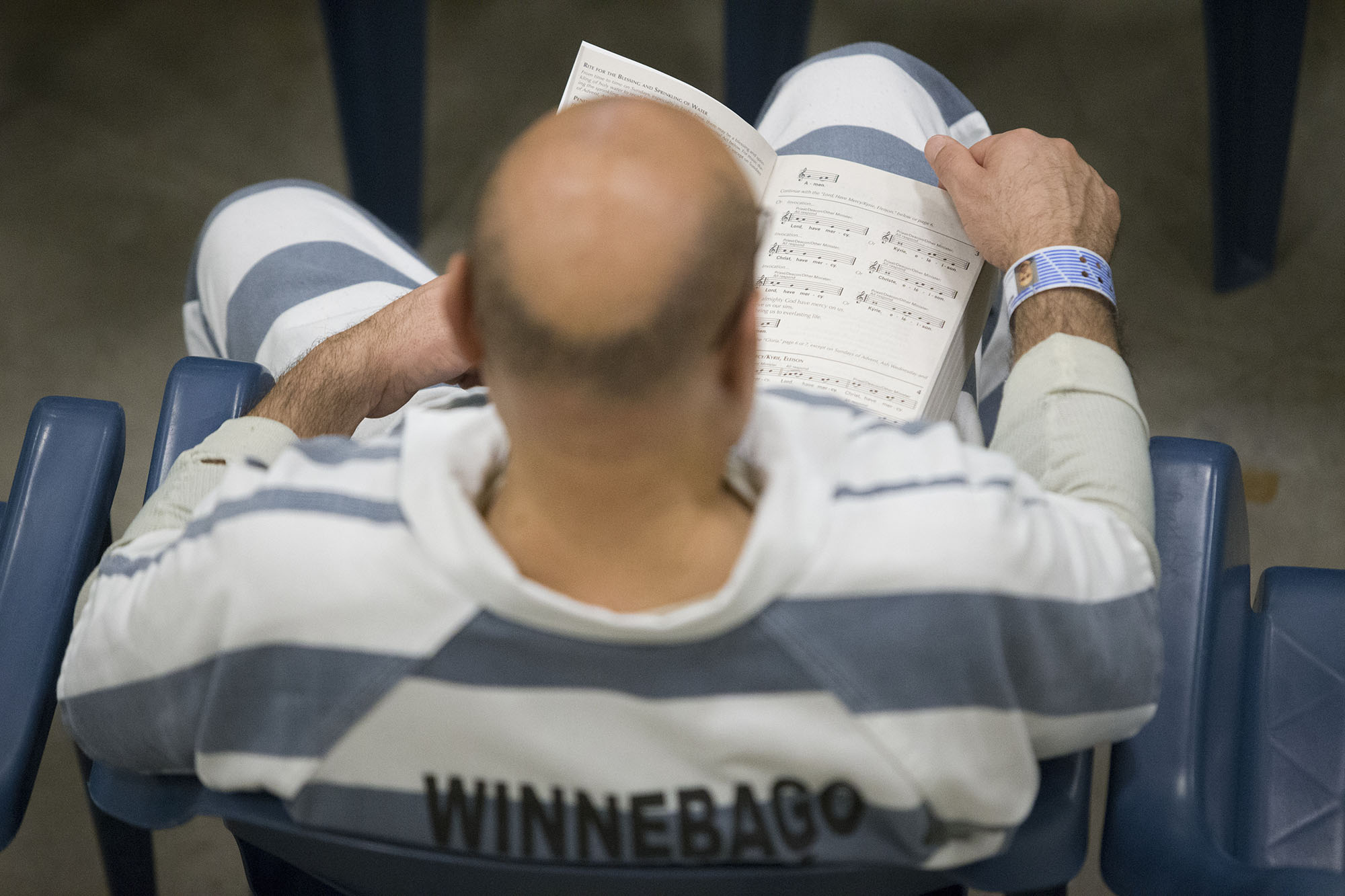 An inmate follows along with the service Sunday, March 27, 2016, during Easter Mass at the Winnebago County Jail in Rockford. MAX GERSH/STAFF PHOTOGRAPHER/RRSTAR.COM ©2016
